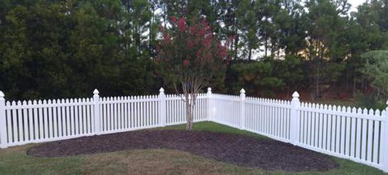 White Vinyl Fence in a Lawn
